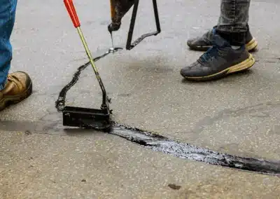 Filling a crack in asphalt with black tar