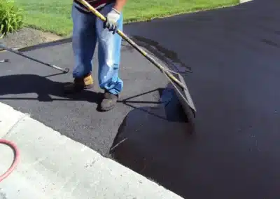 Crew applying seal coating to a freshly laid asphalt surface
