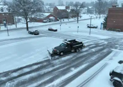 Dump truck with snow plow performing snow removal on a snow-covered street