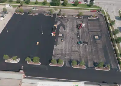 Parking lot resurfacing with fresh asphalt and worn surface