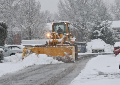 Snowplow clearing snow from a residential street